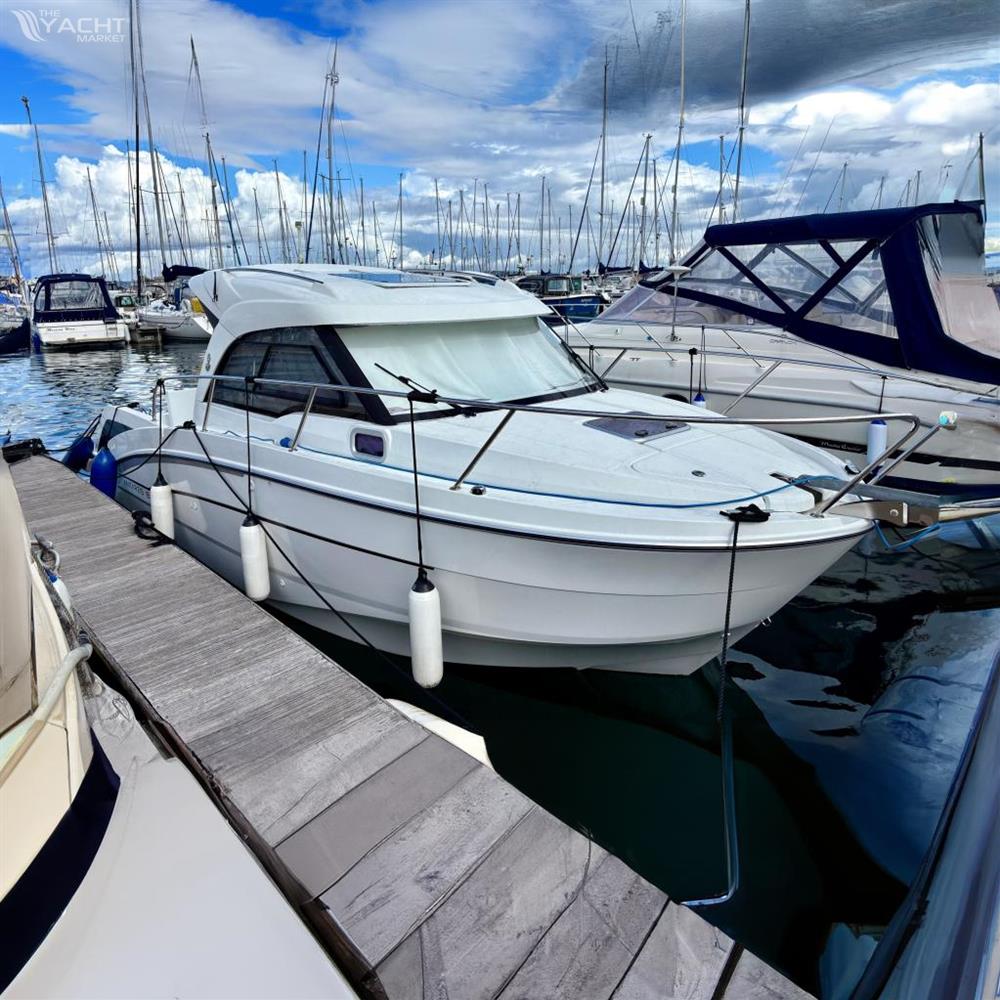 Beneteau Antares 8 - 2019 Beneteau Antares 8 docked in a marina, surrounded by other boats.