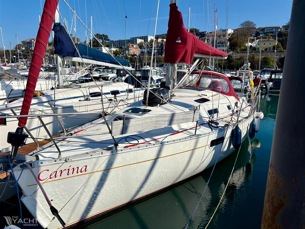 Beneteau Oceanis 321 - 1998 Beneteau Oceanis 321 sailboat docked in a marina, featuring red sails and white hull.