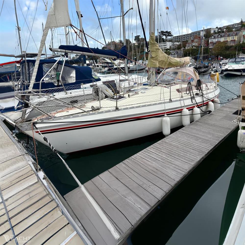 Jeanneau Melody 34 - 1981 Jeanneau Melody sailboat docked at a marina, surrounded by other boats.