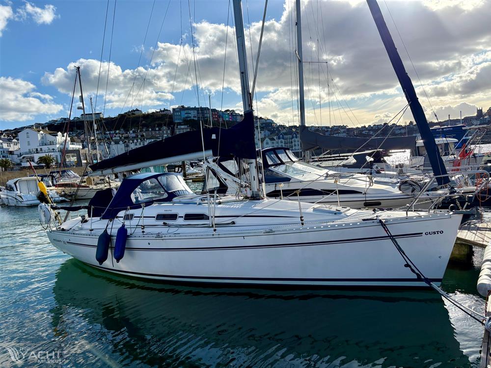 Elan 333 - 2004 Elan 333 sailboat docked in a sunny marina, surrounded by other boats.