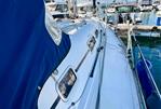 Elan 333 - 2004 Elan 333 sailboat docked in marina, featuring sleek design and blue canopy.