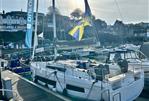 Dufour 41 - 2025 Dufour 41 sailboat docked at a marina with flags and surrounding boats.