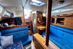 Moody 34 - Interior of a 1985 Moody 34 sailboat with blue seating and wooden finishes.