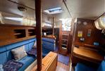 Moody 34 - Interior of a 1985 Moody 34 sailboat with blue seating and wooden finishes.
