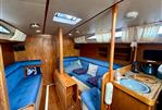 Moody 34 - Interior of a 1985 Moody 34 sailboat with blue seating and wooden finishes.