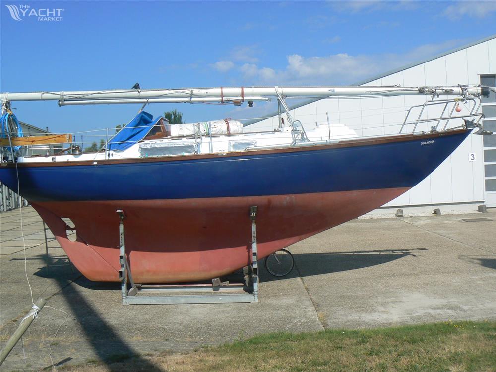Rustler 31 - 1969 Rustler 31 sailboat with blue hull and red keel on a stand outdoors.