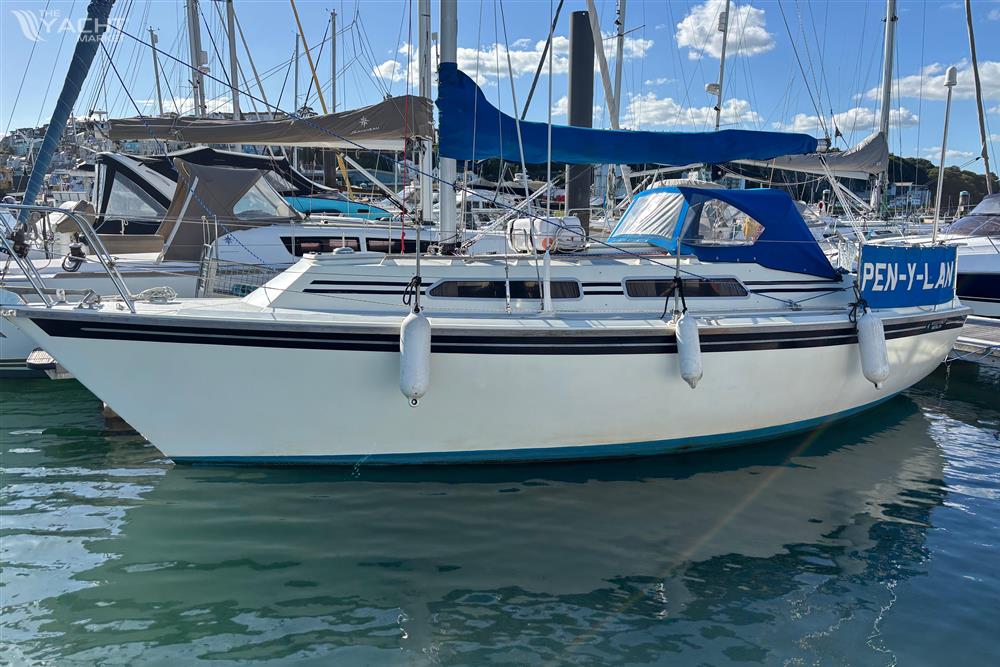 Westerly Merlin - 1986 Westerly Merlin sailboat docked in marina, blue canopy, calm water, clear sky.