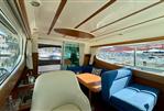 Jeanneau Merry Fisher 925 - Interior of 2008 Jeanneau Merry Fisher 925 boat with blue seating and wooden accents.