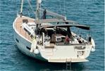 Dufour 530 - 2023 Dufour 530 yacht on clear blue water, rear view with deck and canopy.
