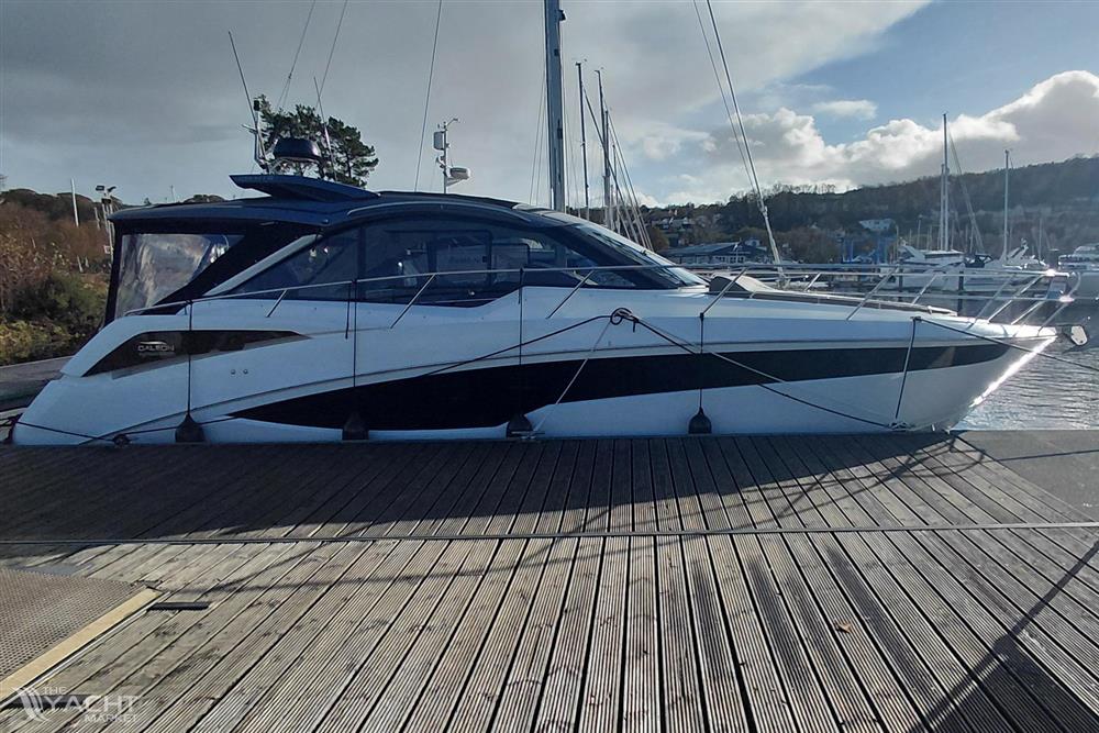 Galeon 405 HTS - 2023 Galeon 405 HTS yacht docked at a marina under a partly cloudy sky.