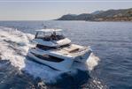 Aquila 46 Yacht - 2026 Aquila 46 Yacht cruising on open sea with scenic coastal backdrop.
