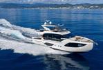 Absolute 70 Fly - Luxury yacht Absolute 70 Fly 2026 cruising on open sea with scenic coastline.