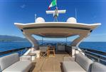 Absolute 70 Fly - Luxurious 2026 Absolute 70 Fly yacht deck with seating, ocean view, and Italian flag.
