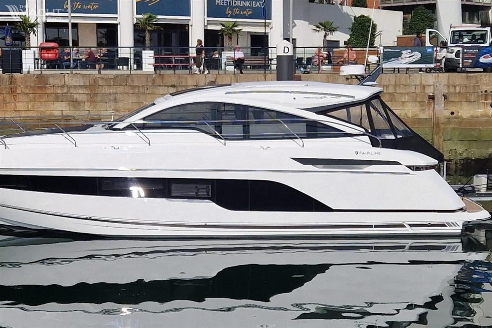 Fairline Targa 45 GT - 2025 Fairline Targa 45 GT luxury yacht docked at a marina, reflecting on water.