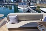 Fairline Targa 45 GT - 2022 Fairline Targa 45 GT yacht interior with seating and table in a marina setting.