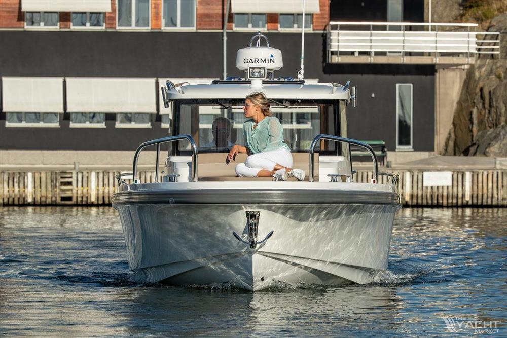Nimbus Commuter 9 - A woman sits on the bow of a 2026 Nimbus Commuter 9 boat in a marina.