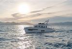 Nimbus 495 Flybridge - 2026 Nimbus 495 Flybridge yacht cruising at sunset on open sea.