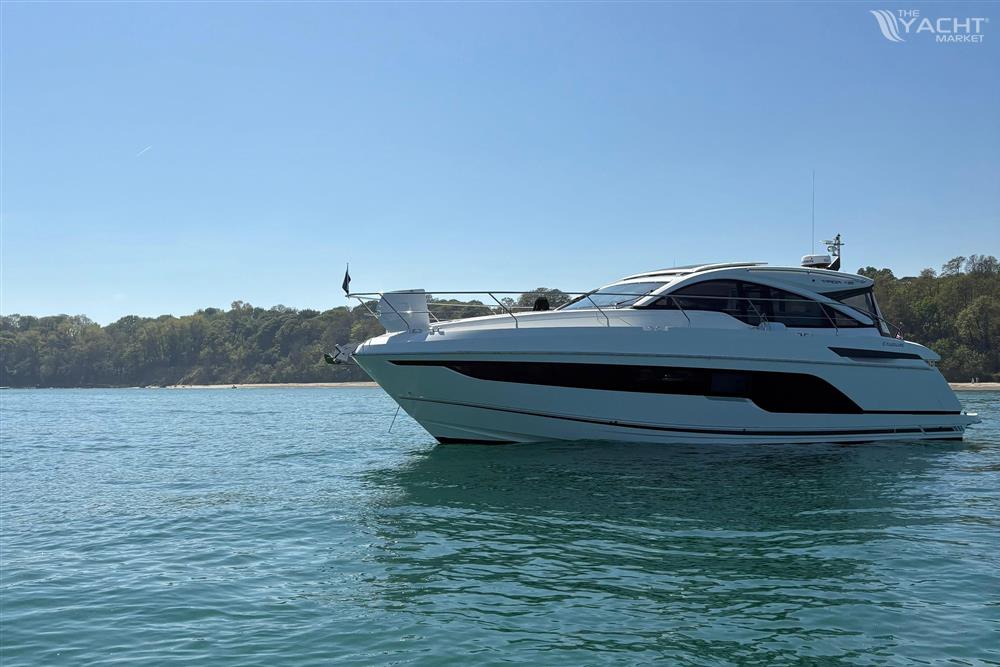 Fairline Targa 45 GT - 2022 Fairline Targa 45 GT yacht on calm water near a forested shoreline.