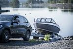 Falcon BR5 - SUV towing a 2026 Falcon BR5 boat by a serene lake.