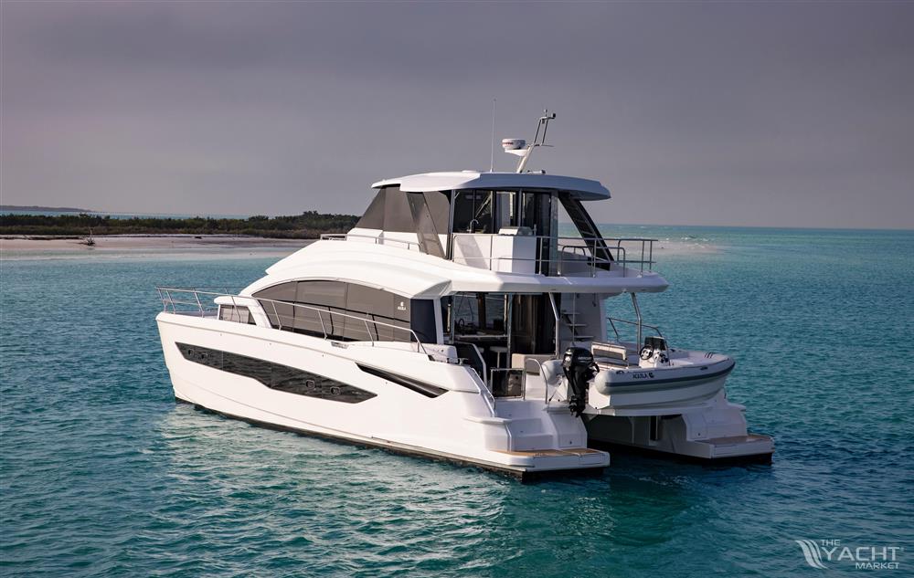 Aquila 54 Yacht - 2026 Aquila 54 Yacht on turquoise water near a sandy shore.