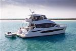 Aquila 54 Yacht - Aquila 54 Yacht 2026 cruising on clear blue water near a sandy shoreline.