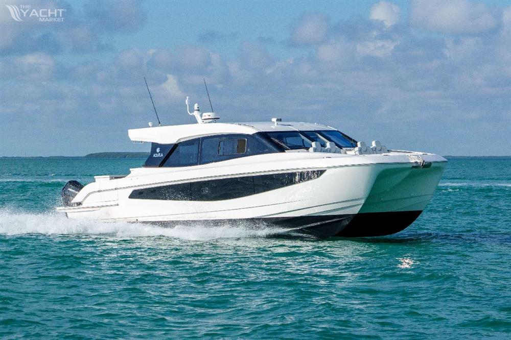 Aquila 42 Coupe - 2026 Aquila 42 Coupe cruising on turquoise waters under a partly cloudy sky.
