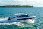 Aquila 42 Coupe - 2026 Aquila 42 Coupe cruising on open water near a lush island.