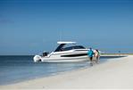 Aquila 32 Sport - 2026 Aquila 32 Sport boat on sandy beach with couple walking nearby.