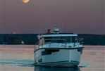 Aquador 300 HT - Aquador 300 HT boat cruising at sunset with full moon in background, 2026 model.