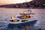 Absolute 60 Fly - Luxurious 2026 Absolute 60 Fly yacht at sunset near coastal town.