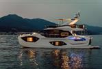 Absolute 52 FLY - Luxurious 2026 Absolute 52 FLY yacht illuminated on serene waters at dusk.