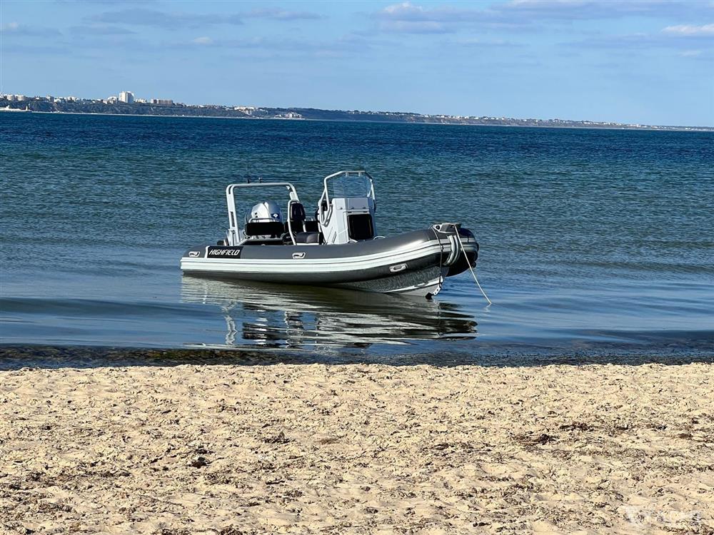 Highfield DL 540 - 2019 Highfield DL 540 boat anchored near sandy beach with calm blue water.