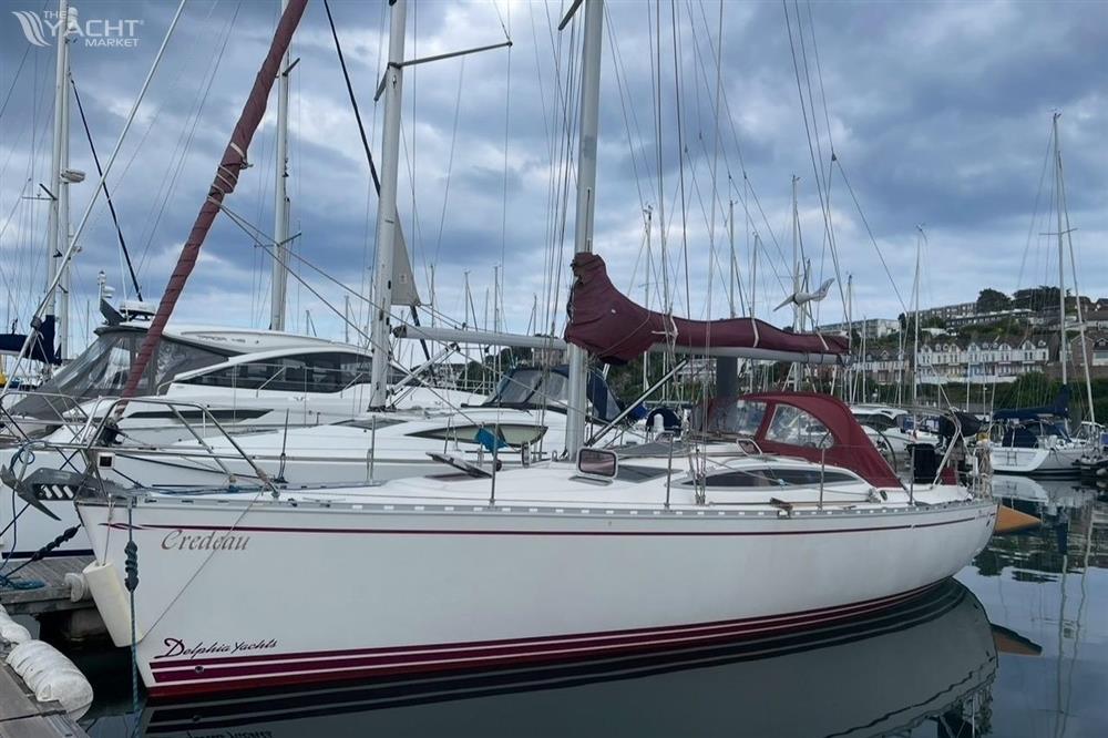 Delphia 37 - Sailboat Delphia 37, 2006 model, docked in a marina under cloudy skies.