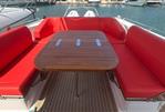 Nimbus T11 T-TOP - 2022 Nimbus T11 T-TOP boat with red seating and wooden table in a marina.
