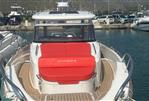 Nimbus T11 T-TOP - 2022 Nimbus T11 T-TOP boat docked at marina, featuring red seating and sleek design.