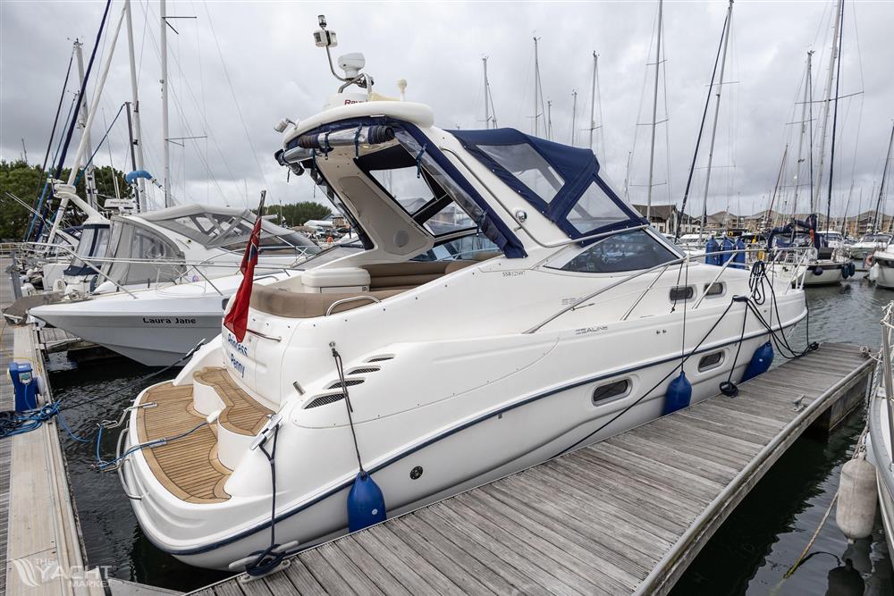 Sealine S34 - 2004 Sealine S34 yacht docked at marina, featuring sleek design and blue canopy.
