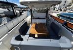Nimbus T11 T-TOP - 2022 Nimbus T11 T-TOP boat interior with seating and wooden table in a marina setting.