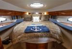Princess V42 - Luxurious cabin interior of a 2000 Princess V42 yacht with plush bedding and elegant wood finishes.
