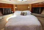Princess V53 - Luxurious bedroom interior of 2006 Princess V53 yacht with elegant bedding and wood accents.