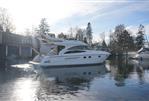 Princess 42 Flybridge Motor Yacht - 2006 Princess 42 Flybridge Motor Yacht on calm water, surrounded by trees and buildings.
