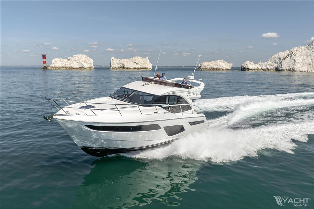 Princess F50 - 2022 Princess F50 yacht cruising near rocky coastline and lighthouse.