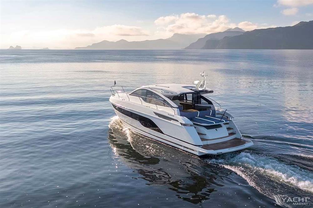Fairline Targa 47 GT - Fairline Targa 47 GT 2026 cruising on calm waters with mountain backdrop.