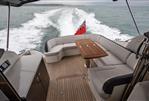 Princess V48 - Luxurious 2014 Princess V48 yacht with elegant seating and wooden deck cruising at sea.